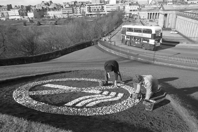 Workmen George Nisbet and Mark Miller place the small stones making up a giant 'No Smoking' symbol at the Mound in 1989.