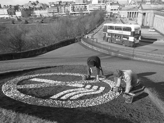 Workmen George Nisbet and Mark Miller place the small stones making up a giant 'No Smoking' symbol at the Mound in 1989.