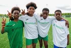 St Joseph's Primary School players pictured after taking part in the last game in the 24-hour football challenge at Hibs' East Mains Training Ground near Tranent. Pictured are Aloaye Sule and Destiny Omenyima in the centre, each with their younger brother.