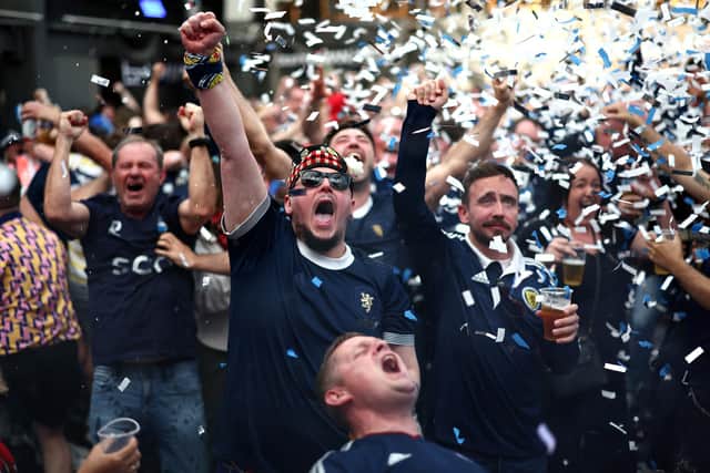 Fans celebrate Scotland qualifying for the World Cup at a fan zone in Glasgow. Picture: Jeff J Mitchell/Getty Imageses