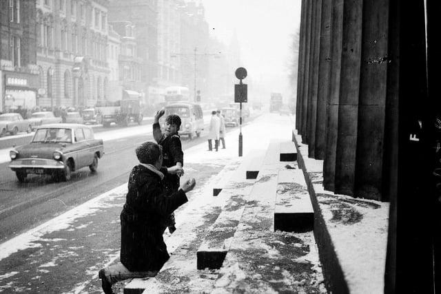 Two boys have a snowball fight outside RSA in Princes Street.