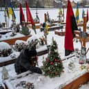A woman decorates a Christmas tree at the grave of her husband, Oleg Skybyk, a Ukrainian serviceman who was killed resisting the Russian invasion of Ukraine (Picture: Yuriy Dyachyshyn/AFP via Getty Images)