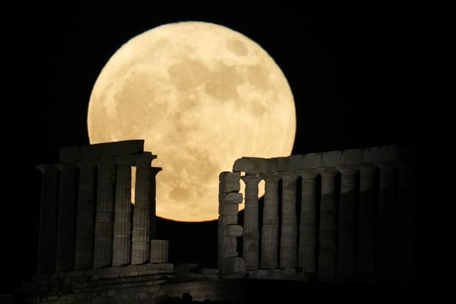 The strawberry full moon rises behind the ancient temple of Poseidon at Cape Sounion, about 70 kilometers (45 miles) south of Athens, Greece.(AP Photo/Thanassis Stavrakis)