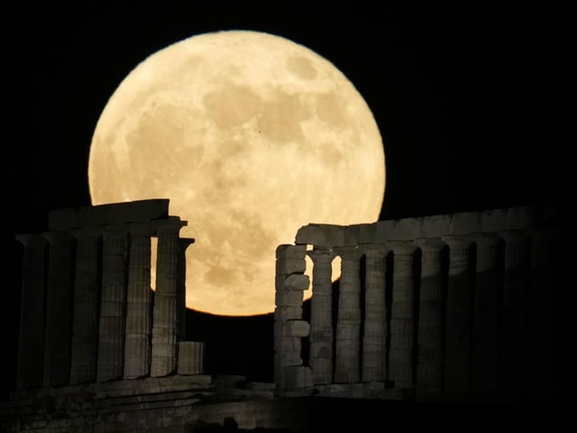 The strawberry full moon rises behind the ancient temple of Poseidon at Cape Sounion, about 70 kilometers (45 miles) south of Athens, Greece.(AP Photo/Thanassis Stavrakis)