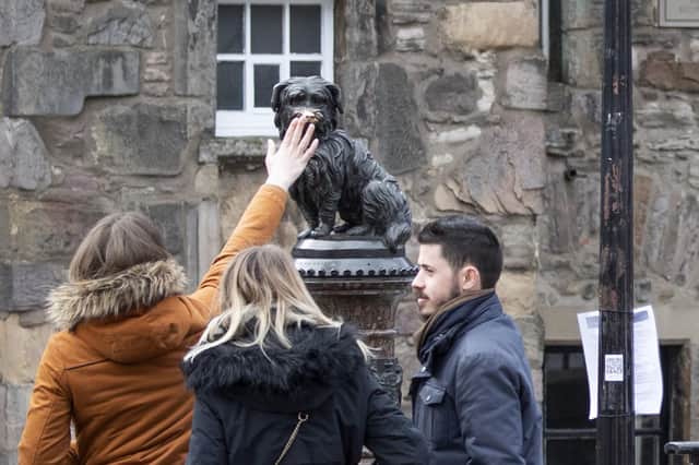 Tourists continue to 'touch the nose' of the Greyfriars Bobby statue in Edinburgh for good luck last week (Picture: Jane Barlow/PA Wire)