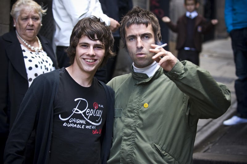 Oasis lead singer Liam Gallagher happily poses for pictures with fans outside The Halfway House pub on Fleshmarket Close.
