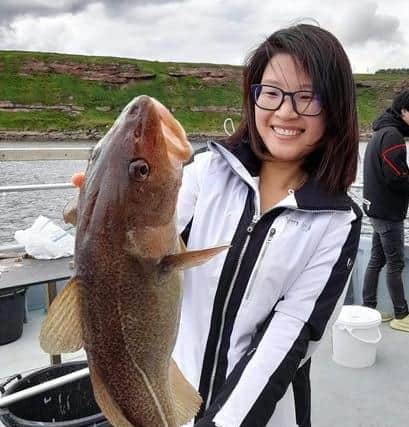 Jinhua Wu with a 9lb cod. Contributed by Aquamarine Charters