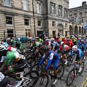 Riders cycle down the Royal Mile at the start of the men's Elite Road Race at the Cycling World Championships in Edinburgh on August 6