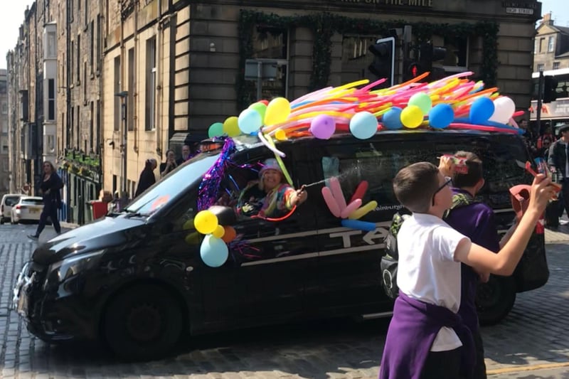 The annual outing, known for the spectacular colourful taxis passes through the Royal Mile. This guest takes delight in soaking the crowds from the vibrant taxi