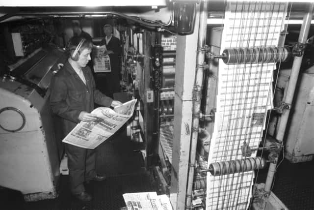 A printer, wearing ear protectors to guard against the roar of the machines, checks a copy of the Evening News as it comes off the presses in the basement of the newspaper's headquarters at North Bridge, January 1990.