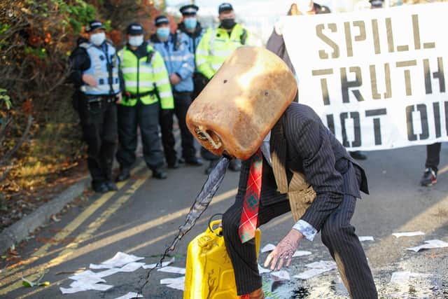 Ocean Rebellion protesters are overlooked by police, as they 'vomit oil' at Ineos Grangemouth.