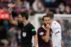 Referee Kevin Clancy shows Hearts midfielder Jorge Grant a red card against Motherwell.