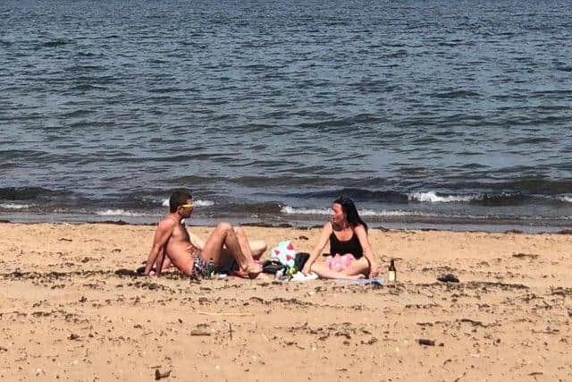 A couple are pictured soaking up the sun at Portobello Beach.