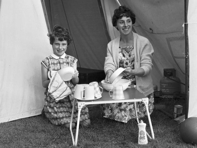 Mum and daughter wash the dishes outside their tent at the Granton campsite on Marine Drive in July 1966.