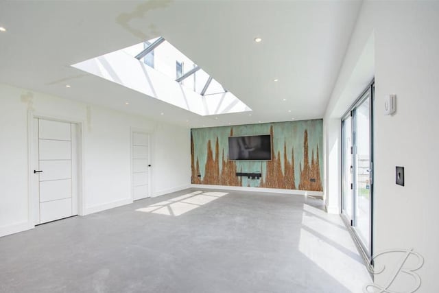 The dining room can only be described as spectacular, especially with its skylight, allowing natural light to flood in. Its bi-folding doors lead into the garden.