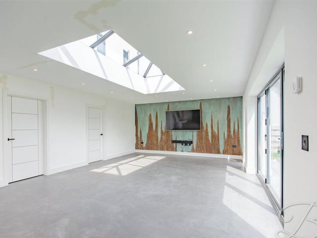 The dining room can only be described as spectacular, especially with its skylight, allowing natural light to flood in. Its bi-folding doors lead into the garden.