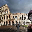 A man wearing a protective mask passes by the Coliseum in Rome (Photo: Alberto PIZZOLI / AFP) (Photo by ALBERTO PIZZOLI/AFP via Getty Images)