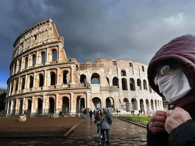 A man wearing a protective mask passes by the Coliseum in Rome (Photo: Alberto PIZZOLI / AFP) (Photo by ALBERTO PIZZOLI/AFP via Getty Images)