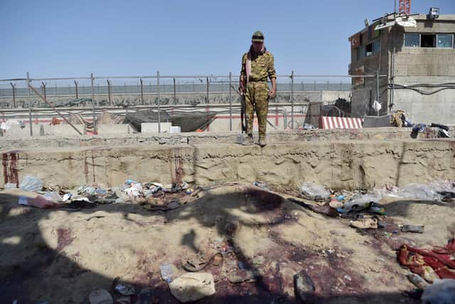 A Taliban fighter stands guard at the site of two powerful explosions, which killed scores of people including 13 US troops on August 26, at Kabul airport on August 27, 2021. (Image credit: Wakil Kohsar/AFP via Getty Images)