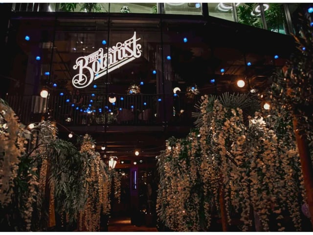 The entrance to The Botanist is decorated with lots of greenery.