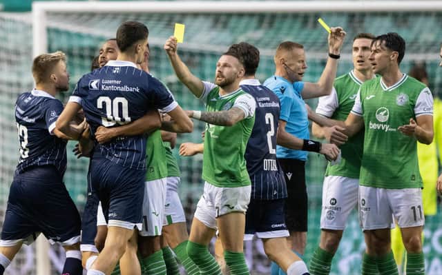 Martin Boyle jokingly books his opponents after picking up a yellow card dropped by referee Robertas Valikonis during the first leg encounter between Hibs and Luzern at Easter Road. Picture: SNS