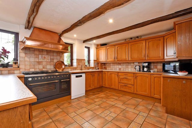 The kitchen is fitted with a range of oak units. Included within the sale is an oven range. The breakfast area has an oak floor, an exposed brick column and a ceiling beam.