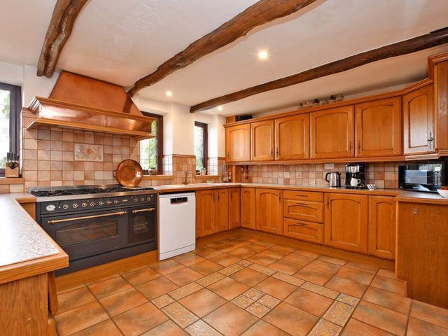 The kitchen is fitted with a range of oak units. Included within the sale is an oven range. The breakfast area has an oak floor, an exposed brick column and a ceiling beam.