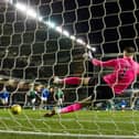 Hibs goalkeeper Matt Macey is beaten by Kemar Roofe's penalty for the only goal of the game
