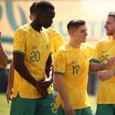 Thomas Deng, Cammy Devlin and Jason Cummings pose for Australia's official team photo in Doha before their opener against France. Picture: Robert Cianflone/Getty
