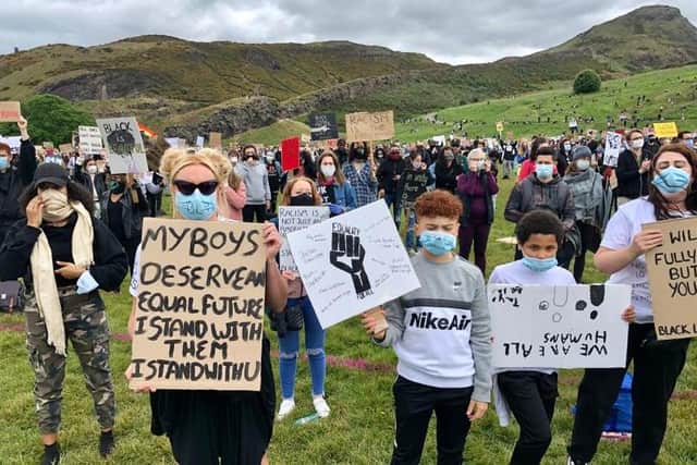 A woman stands with a sign pushing for equality as she joins others at the Black Lives Matter protest in Edinburgh