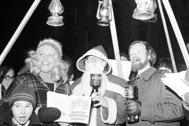 Scottish politicians Margo MacDonald and Robin Cook join Santa Claus and carol singers for a carol service in aid of the homeless charity Shelter at Edinburgh's West End in December 1978.