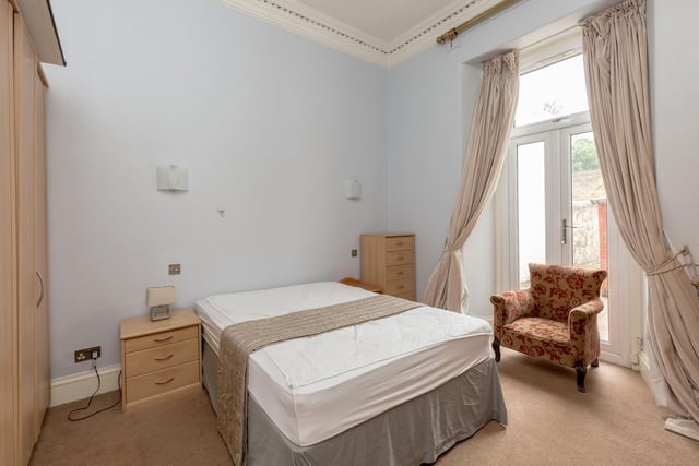 The ground floor includes three double bedrooms, with bedroom one featuring French doors to the rear garden, and a modern bathroom with a white three piece suite with shower above the bath and vanity storage.