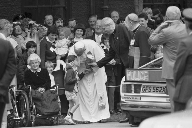 Pope John Paul II hugs a small boy who presented him with flowers at Turnhouse Airport at the start of his visit to Scotland.