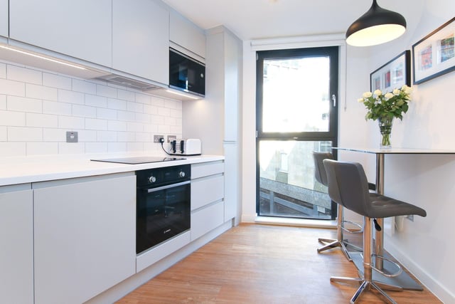 The kitchen is fitted with a range of contemporary cabinets and Corian worktops.