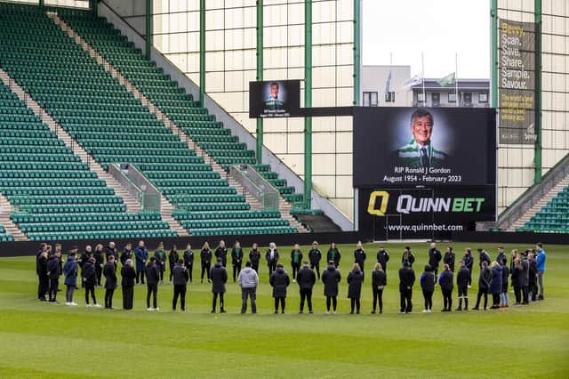Hibs players and staff at Easter Road gather around the centre circle to hold a minute's silence as a mark of respect for Ron Gordon