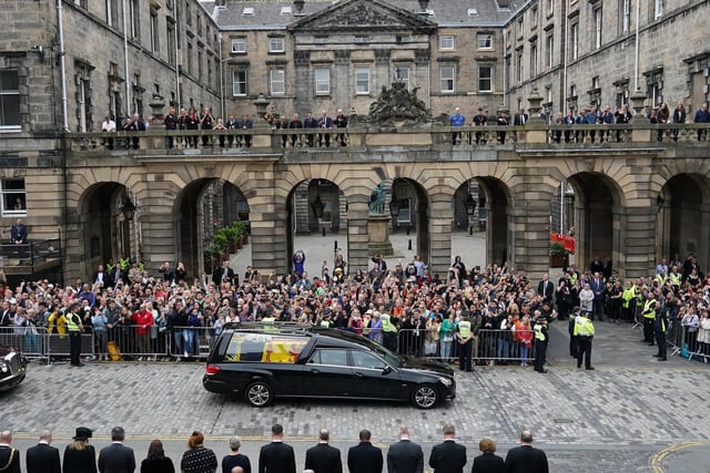 Crowds watch the cortege carrying the coffin of the late Queen Elizabeth II by Mercat Cross in Edinburgh.
