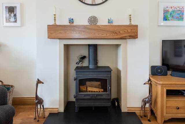 The sitting area has a feature fireplace with log burning stove set on a Brazilian slate hearth with timber mantle.
