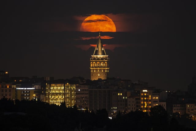 The moon reached its full stage on Tuesday, as pictured here behind the Galata Tower in Istanbul, Turkey, (AP Photo/Emrah Gurel)