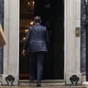 Prime Minister Rishi Sunak, soaked by rain, walks back in to 10 Downing Street after calling a general election for July 4