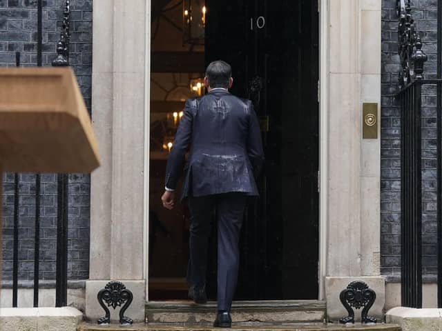 Prime Minister Rishi Sunak, soaked by rain, walks back in to 10 Downing Street after calling a general election for July 4
