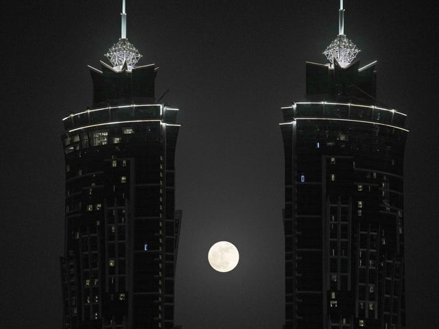 The full moon rises between two towers, in Dubai, United Arab Emirates, Tuesday, June 14, 2022. (AP Photo/Kamran Jebreili)