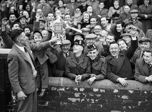 Mathie Chalmers Hearts groundsman shows the Scottish Cup to a section of the crowd at Tynecastle in 1956. Hearts had beaten Celtic at Hampden Park in the Scottish Cup final, 1956.