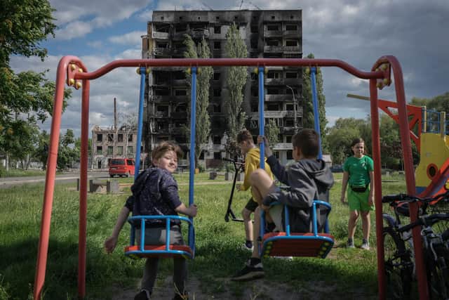 Children play in a park amid evidence of Vladimir Putin's destruction in Borodianka, Ukraine (Picture: Christopher Furlong/Getty Images)