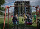 Children play in a park amid evidence of Vladimir Putin's destruction in Borodianka, Ukraine (Picture: Christopher Furlong/Getty Images)