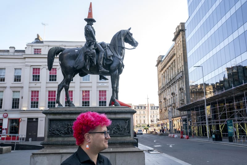 Gallery steward Louisa Mcgeachie, stands by the Duke of Wellington statue, which now wears a traffic cone, consider by many to be the first original piece of 'street art' outside Glasgow's GoMA where the new show by street artist Banksy 'Cut & Run' opens this Sunday, revealing for the first time the stencils used to create many of the artist's most iconic works.