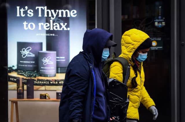 Pedestrians wearing a face mask or covering due to the COVID-19 pandemic, walk on Buchanan Street in central Glasgow.