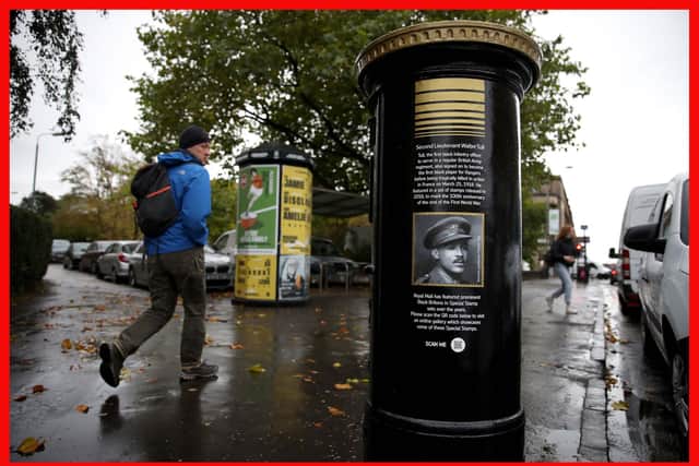 t Members of the public walk past a black postbox featuring an image of Second Lieutenant Walter Tull in Glasgow, one of unveiled by Royal Mail to mark Black History Month.