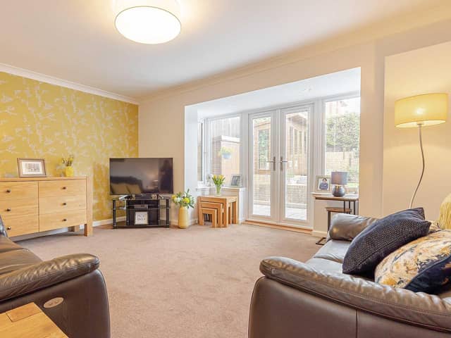 The spacious living room with a box bay window and double doors which lead out into the sun trap garden.