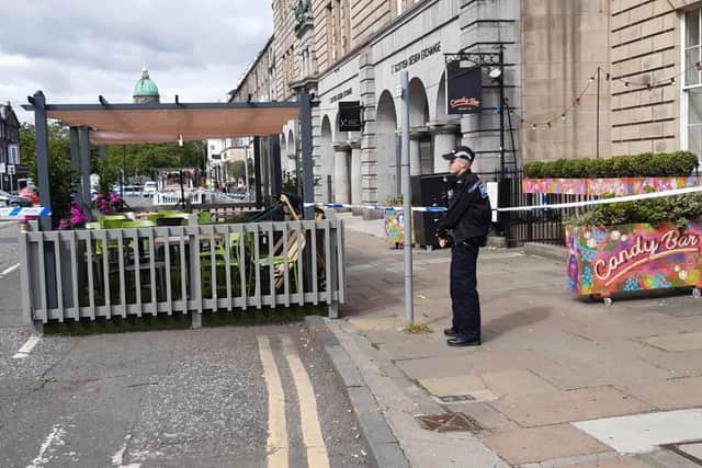 An officer stands guard at the cordoned off area on George Street this morning. Photo by Ian Swanson.