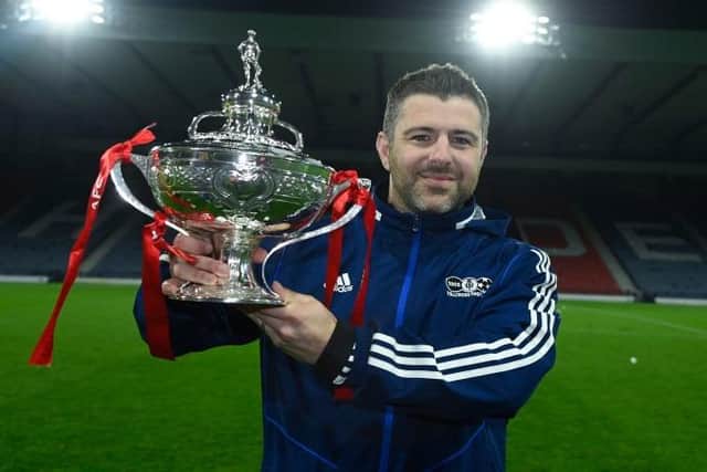 Tollcross Thistle manager Alan McKay celebrates with the Scottish Amateur Cup.